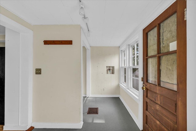 hallway featuring wood walls and track lighting