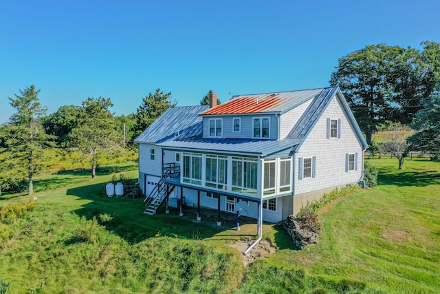 back of property featuring a sunroom and a lawn