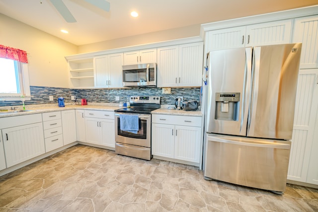 kitchen with white cabinets, ceiling fan, stainless steel appliances, and tasteful backsplash