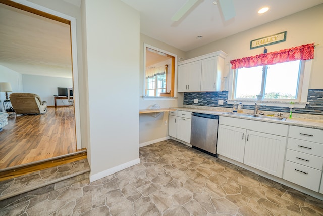 kitchen featuring plenty of natural light, sink, stainless steel dishwasher, and white cabinets