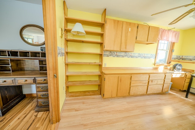 kitchen with light wood-type flooring, built in desk, and ceiling fan