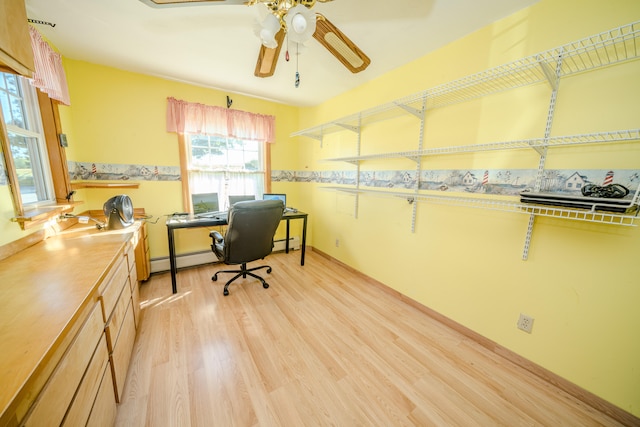 home office with baseboard heating, ceiling fan, and light wood-type flooring