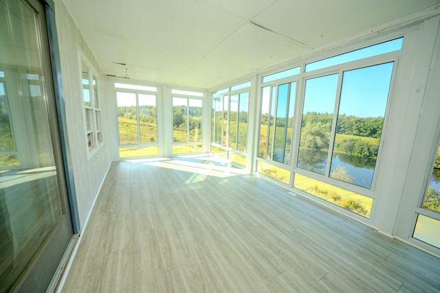 unfurnished sunroom with plenty of natural light and a water view