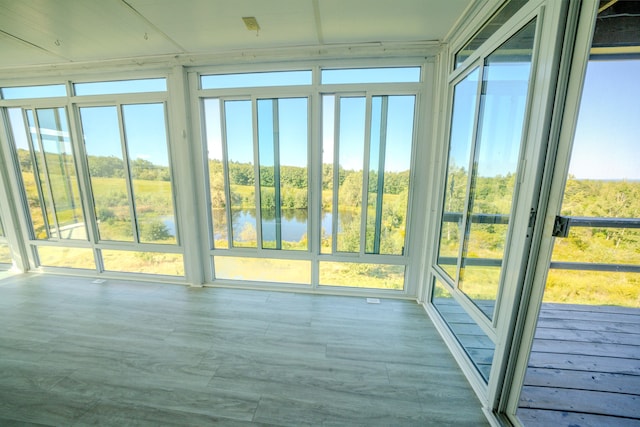 unfurnished sunroom with a healthy amount of sunlight and a water view