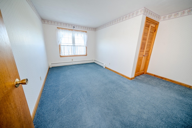 unfurnished bedroom featuring a baseboard heating unit, a closet, and carpet floors