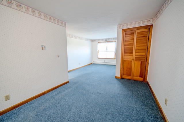 unfurnished bedroom featuring carpet flooring and baseboard heating