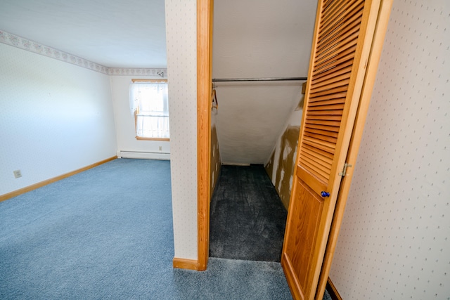 unfurnished bedroom with baseboard heating, a closet, and carpet floors