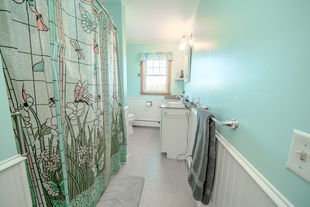 bathroom featuring vanity, toilet, baseboard heating, and walk in shower