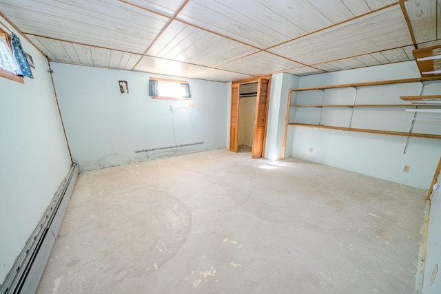 basement featuring a baseboard radiator and a wall unit AC