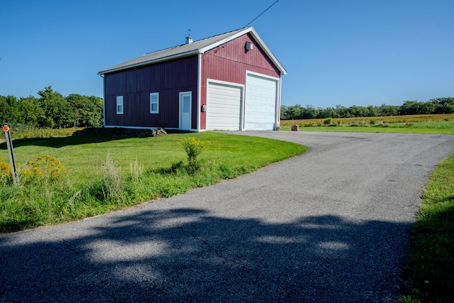 view of outbuilding with a garage and a lawn