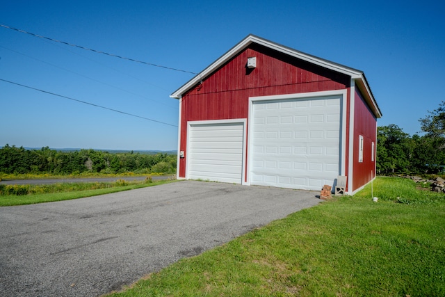 garage with a lawn and wood walls