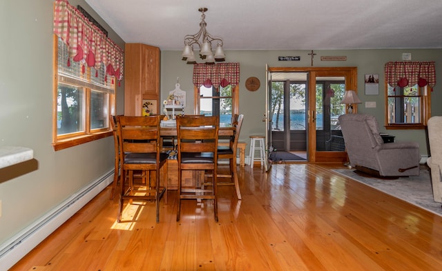 803 Lake Shore Rd, Madawaska, ME 04773 - dining room with french doors, an inviting chandelier, light wood-style floors, and a baseboard radiator