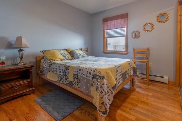 803 Lake Shore Rd, Madawaska, ME 04773 - bedroom with baseboards, wood finished floors, and a baseboard heating unit
