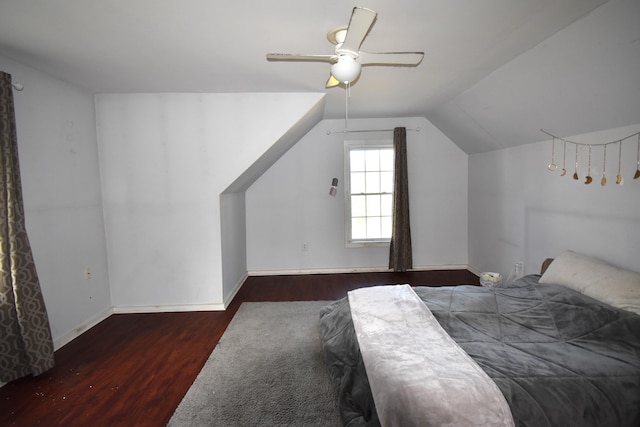 bedroom with ceiling fan, vaulted ceiling, and dark wood-type flooring