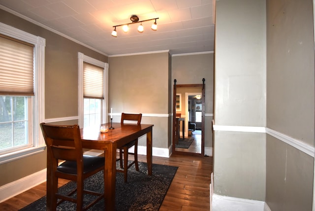 dining area with crown molding, a barn door, and hardwood / wood-style floors