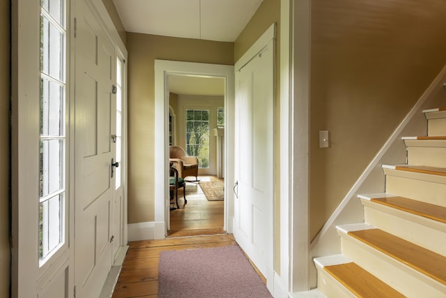 interior space with stairs, baseboards, and light wood-style floors