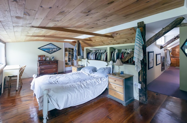 bedroom with hardwood / wood-style floors, lofted ceiling with skylight, wooden ceiling, and a closet