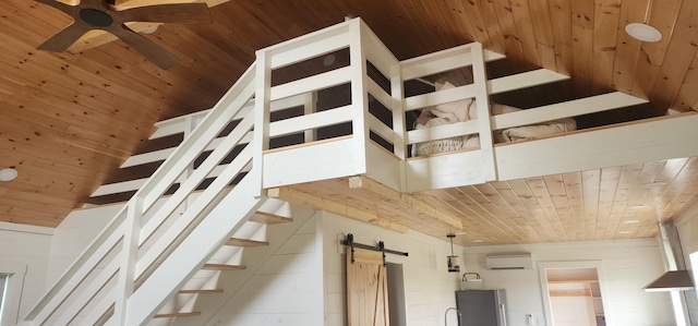 stairs featuring wood ceiling, a barn door, and ceiling fan