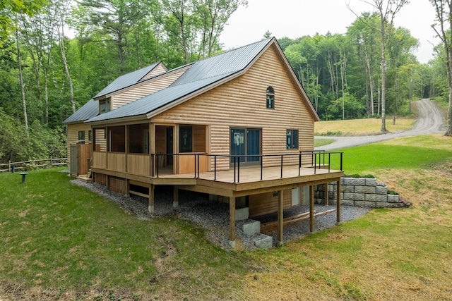 back of house with a wooden deck and a lawn