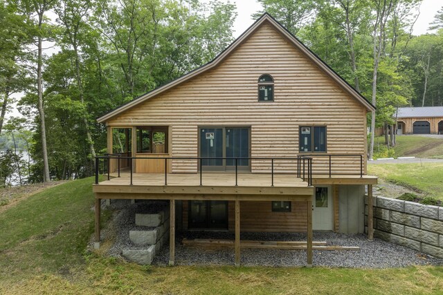 back of house with a wooden deck and a lawn