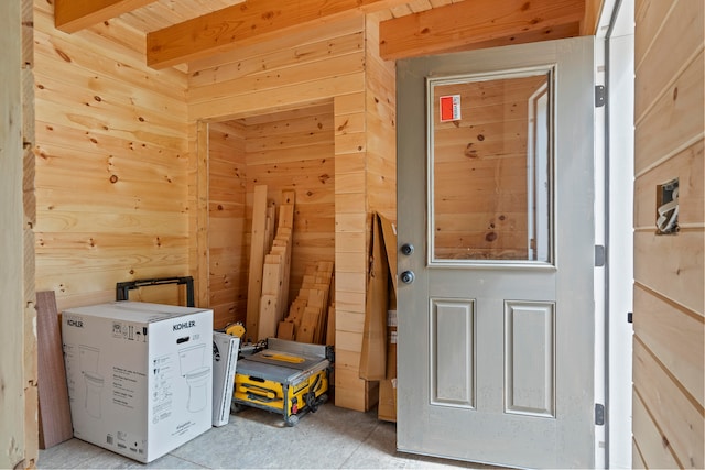 interior space with beamed ceiling and wooden walls