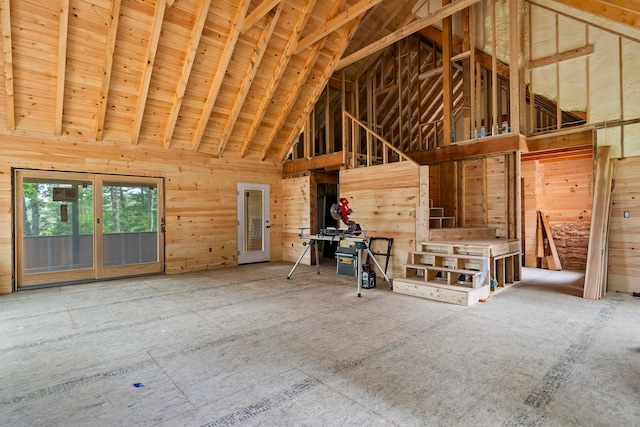 misc room with wood walls and high vaulted ceiling