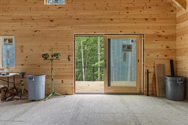 doorway featuring a towering ceiling and wood walls