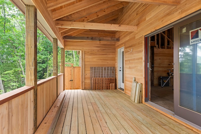 unfurnished sunroom featuring vaulted ceiling with beams