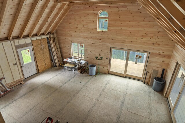 unfurnished living room with wooden ceiling, beamed ceiling, wood walls, and high vaulted ceiling