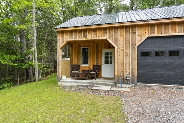 view of outbuilding featuring covered porch and a yard