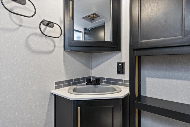 bathroom featuring vanity and decorative backsplash