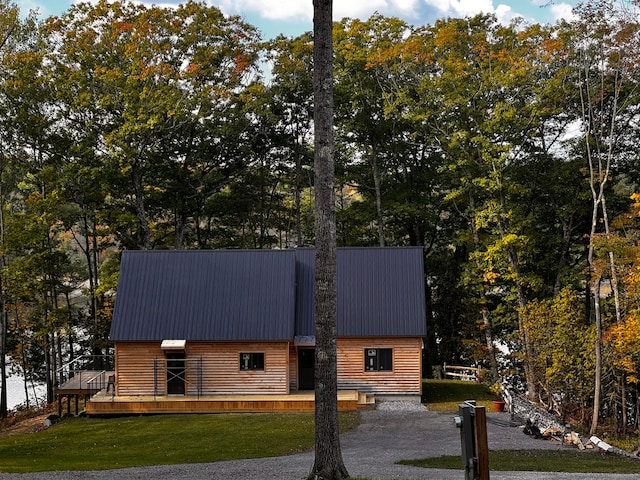 view of front of house with a deck and a front lawn