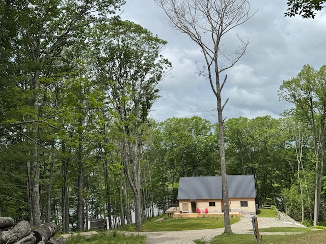 886 Middle Rd, Dresden, ME 04342 - view of front of house featuring a front yard, a metal roof, a wooded view, and driveway