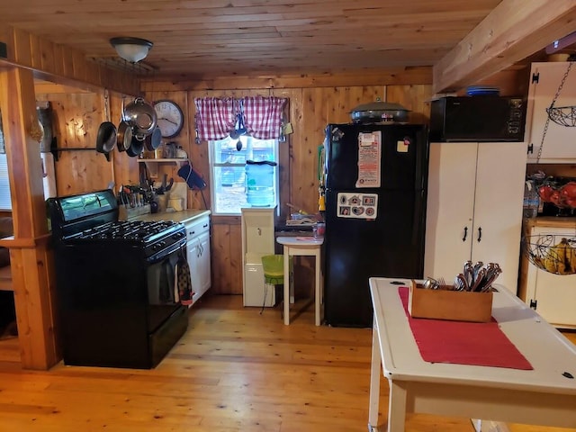 kitchen with black appliances, light hardwood / wood-style flooring, wooden walls, and wood ceiling