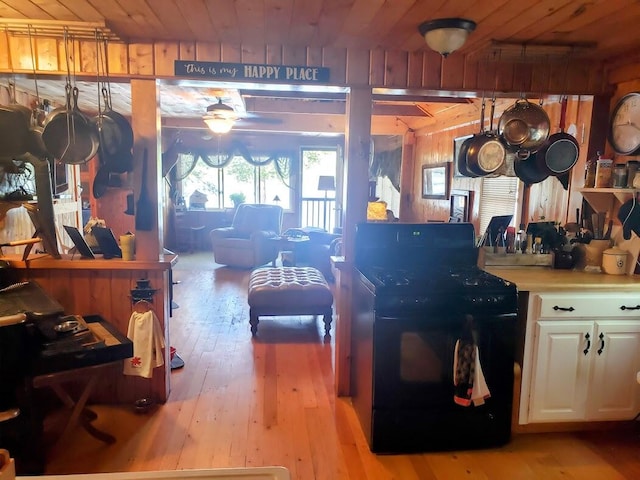 kitchen with wood ceiling, light hardwood / wood-style flooring, white cabinets, and black range with electric cooktop