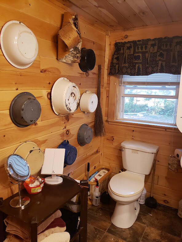 bathroom featuring tile patterned flooring and wooden walls