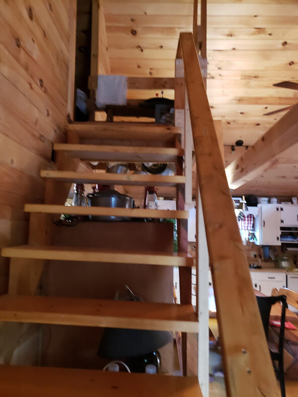 staircase featuring wood walls