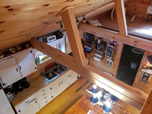 interior space with sink, light hardwood / wood-style flooring, and vaulted ceiling