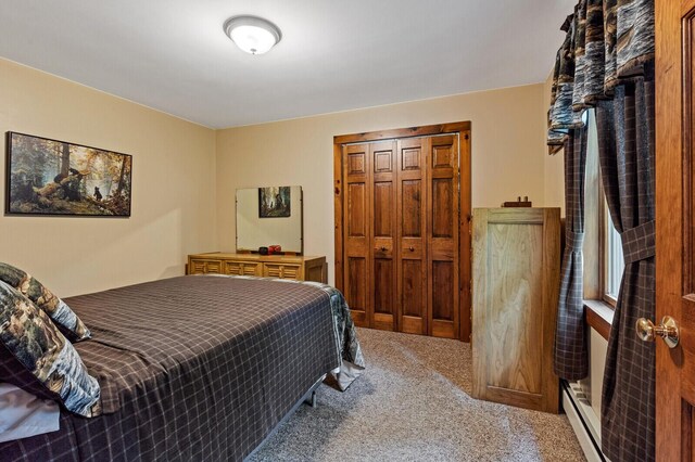 bedroom with a closet, a baseboard radiator, and carpet flooring