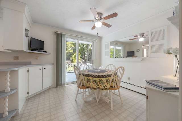 tiled dining room featuring ceiling fan, baseboard heating, ornamental molding, and a textured ceiling