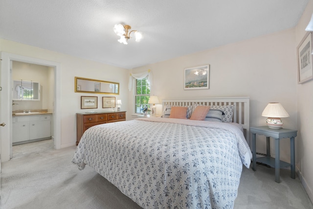 bedroom featuring ensuite bath, sink, and light colored carpet