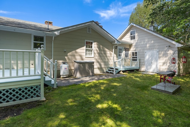 back of house featuring a wooden deck and a lawn