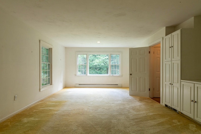 empty room featuring light carpet and a baseboard radiator