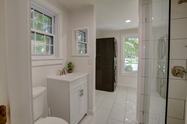 bathroom featuring tile patterned floors, toilet, vanity, baseboards, and walk in shower