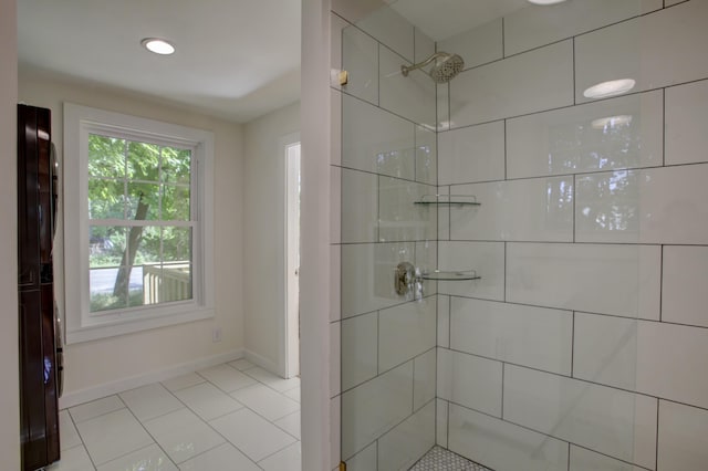 bathroom featuring tiled shower and baseboards