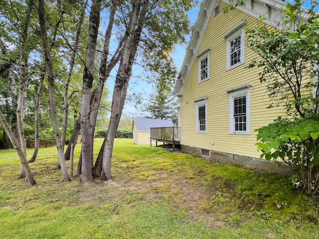 view of side of home featuring a yard and a deck