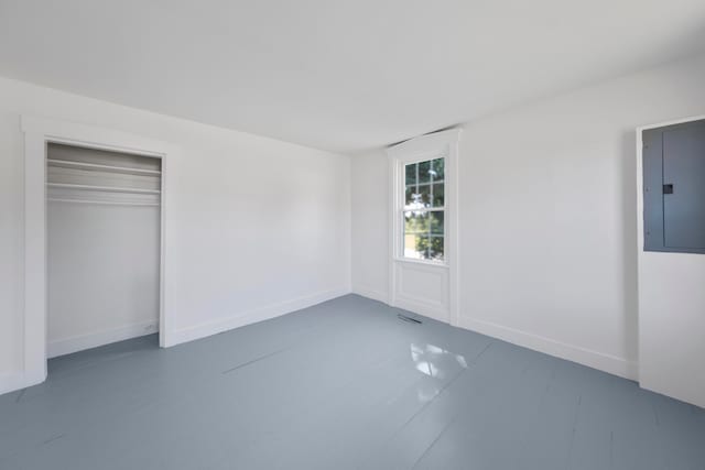 unfurnished bedroom featuring a closet, wood-type flooring, and electric panel