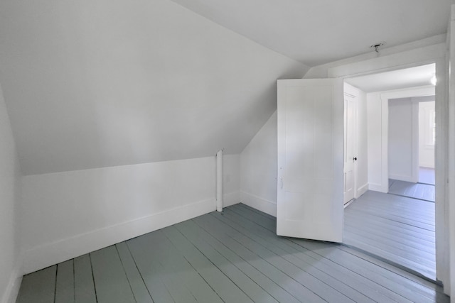 additional living space featuring lofted ceiling and wood-type flooring