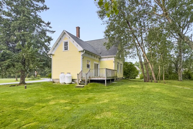 rear view of house with a deck and a lawn