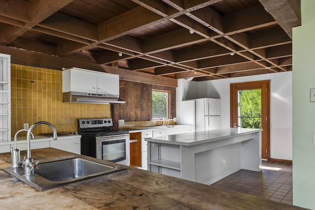 4 Wilson St, Topsham, ME 04086 - kitchen with stainless steel electric range, under cabinet range hood, freestanding refrigerator, white cabinets, and tasteful backsplash
